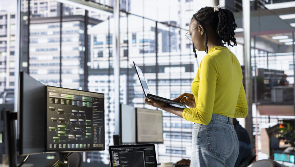 Woman transforming data into predictive models using notebook in office Engineer using laptop device, working with machine learning tech advancing AI critical to innovation of autonomous systems. Woman transforming data into predictive models using notebook