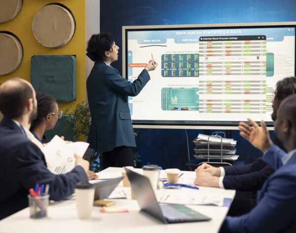 Business partners examining annual sales reports in corporate meeting, developing internal communication strategies to ensure performance. Management team expanding a multinational company.